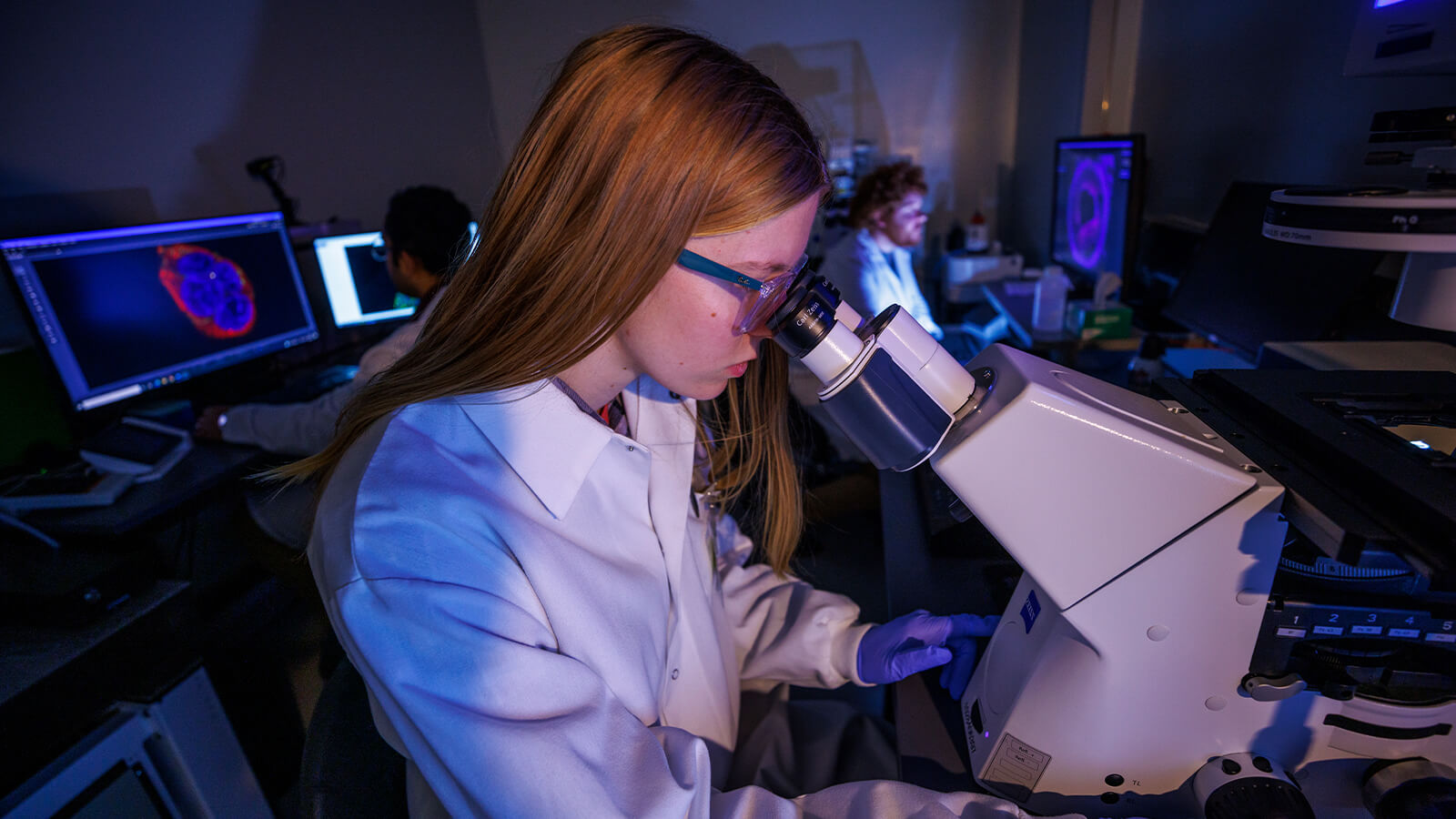 Student in lab looking into microscope