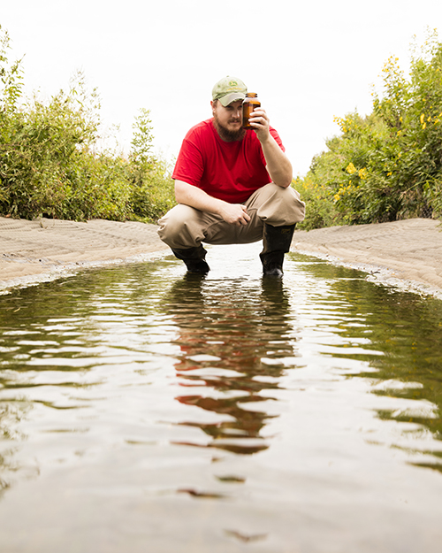 a graduate student conducting a water quality test experiment 