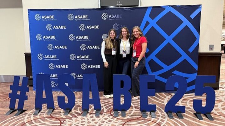 three students stand in front of #ASABE25 sign