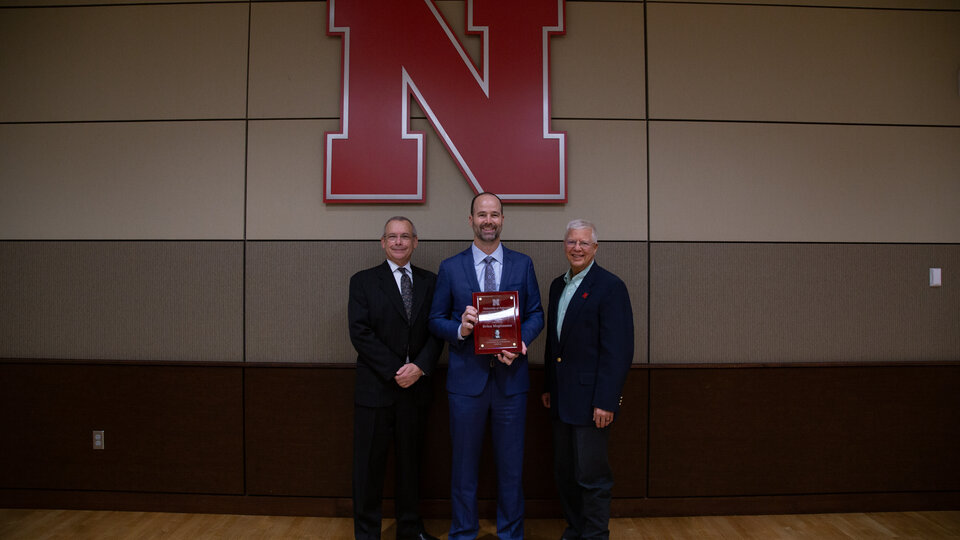 three people standing infront of the N logo in the East Union