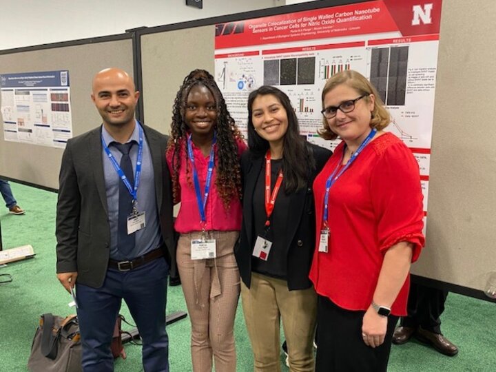 Dr. Iverson, Omer, Portia, and Ivon at BMES in front of Portia's Poster titled 'Organelle Colocalization of Single Walled Carbon Nanotube Sensors in Cancer Cells for Nitric Oxide Quantification'. (October 2023)